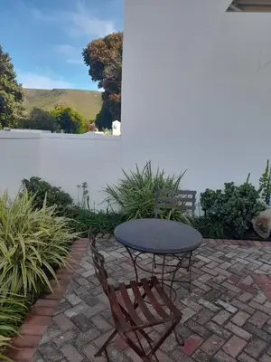 a table and chairs on a brick patio at Marine View in Hermanus