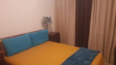 a bedroom with a bed with blue and yellow at THE TREE HOUSE in Grabouw