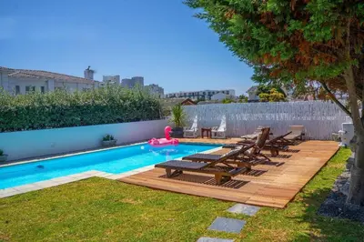 a backyard with a swimming pool and a wooden deck at 7th Wonder Beach Guest House in Cape Town