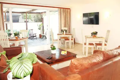 a living room with a couch and a table at 7th Wonder Beach Guest House in Cape Town