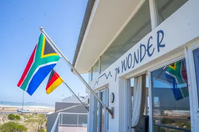 a building with two flags in front of it at 7th Wonder Beach Guest House in Cape Town