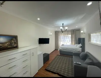 a living room with a bed and a couch at Tia Maria cottage in Cape Town