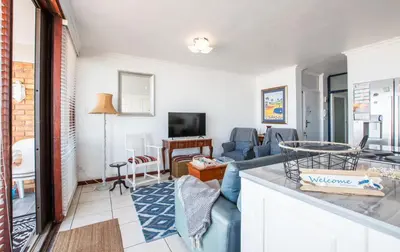 a living room with a couch and a table at Strand Apartment only 30 meters from beach in Cape Town