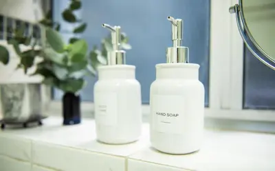 two white bottles sitting on a counter in a bathroom at Strand Apartment only 30 meters from beach in Cape Town
