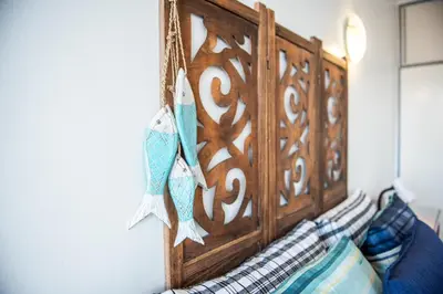 a wooden headboard of a bed in a room at Strand Apartment only 30 meters from beach in Cape Town
