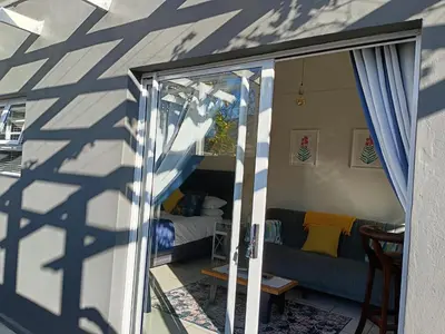 a room with a bed and a sliding glass door at Dalau on Main in Paarl
