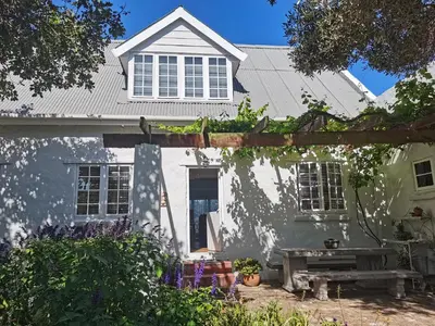 a white house with a fence in front of it at Vermont Lofts in Hermanus
