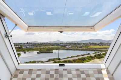 a window in a house with a view of a river at Dolphin Beach H301 by Host Agents in Bloubergstrand