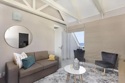 a living room with a couch and a mirror at Dolphin Beach H301 by Host Agents in Bloubergstrand