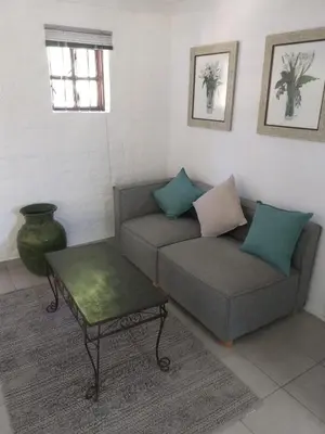 a living room with a couch and a coffee table at Santika Getaway Cottage Stellenbosch in Stellenbosch