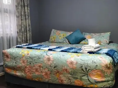 a bed with a colorful comforter and pillows at Step-by-Step Self-Catering and B&B in Bellville