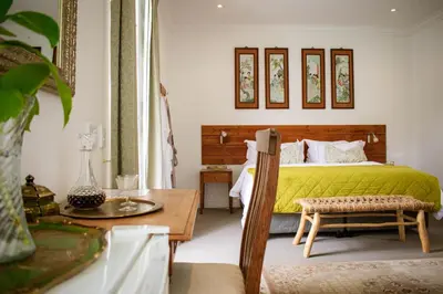 a bedroom with a green bed and a table at Kolonie's Tuin in Stellenbosch