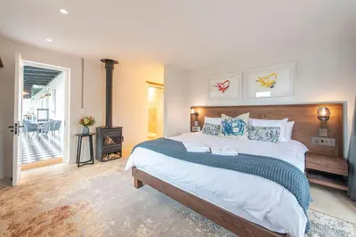 a bedroom with a large bed and a fireplace at La Villa in Franschhoek