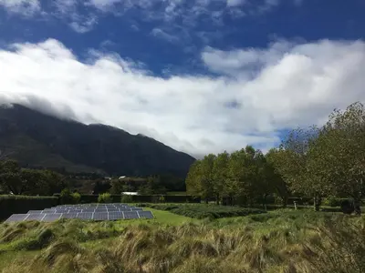 a field with solar panels in front of a mountain at La Villa in Franschhoek