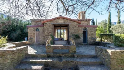 a small stone house with a window and stairs at La Villa in Franschhoek