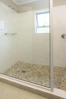 a shower with a glass door in a bathroom at Tuis en Tevrede - 1 Bedroom Flat in Hermanus