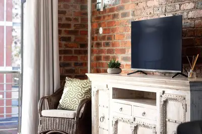 a living room with a tv on top of a cabinet at The Xrossing - free parking in Stellenbosch