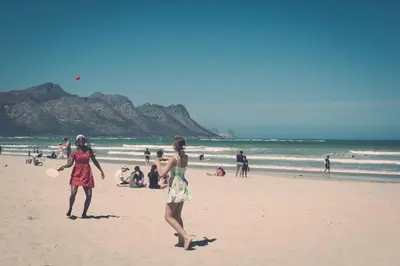 two women playing with a frisbee on the beach at 5 Lantra in Strand