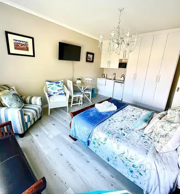 a bedroom with a bed and a chandelier at Hermanus Sea view room in Hermanus