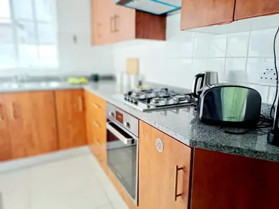 a kitchen with a microwave and a television on a counter at Secure and Modern 2Bed Apartment in Cape Towns Charming Rondebosch in Cape Town
