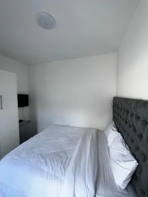 a bed in a white room with a white wall at Beatrice Guesthouse in Cape Town
