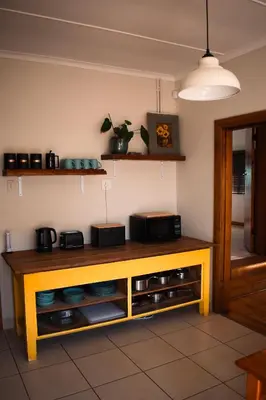 a kitchen with a table with a microwave on it at The Salty Surf Shack in Cape Town