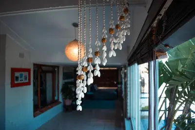 a bunch of coffee cups hanging from a chandelier at The Salty Surf Shack in Cape Town
