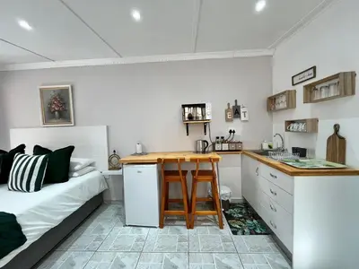 a kitchen with a table and a bed in a room at Ladamon 3 in Paarl