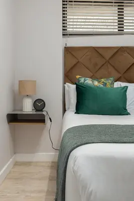 a bedroom with a bed with a green pillow at Burmeister on Park 007 in Cape Town