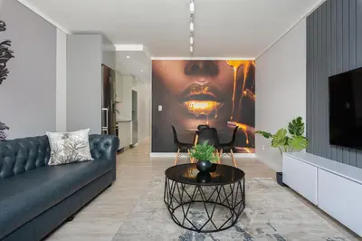a living room with a black couch and a painting at Burmeister on Park 007 in Cape Town