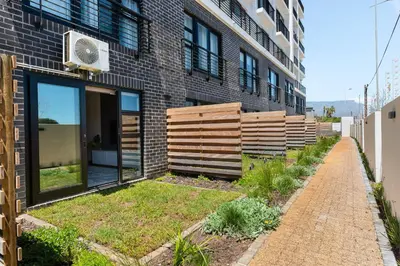 a brick building with a garden in front of it at Burmeister on Park 007 in Cape Town