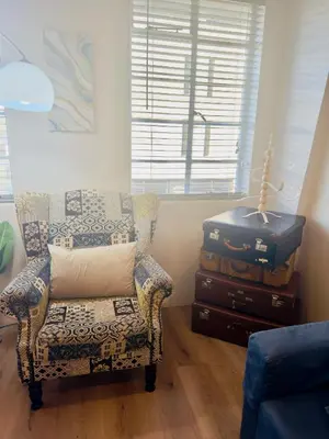 a living room with a chair and a suitcase at Kaneel Suiker - Paarl - Self Catering Apartment in Paarl