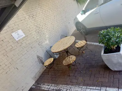 a picnic table and benches on a brick sidewalk at Kaneel Suiker - Paarl - Self Catering Apartment in Paarl