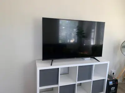 a flat screen tv on top of a white entertainment center at The Lazy Expat - Paarl - Self Catering Apartment in Paarl