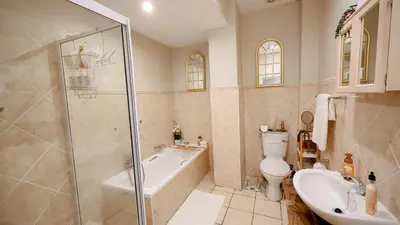 a bathroom with a shower and a toilet and a sink at The Lazy Expat - Paarl - Self Catering Apartment in Paarl