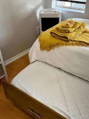 a bed with white sheets and yellow towels on it at The Skinny Expat - Paarl - Self Catering Apartment in Paarl