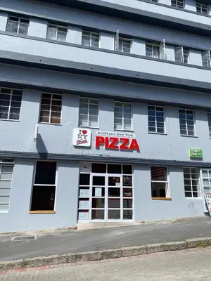 a white building with a pizza sign on it at The Skinny Expat - Paarl - Self Catering Apartment in Paarl