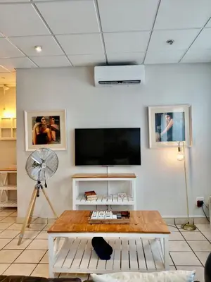 a living room with a table and a flat screen tv at The Tipsy Expat - Paarl - Self Catering Apartment in Paarl