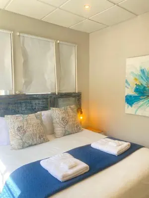 a bedroom with a bed with two towels on it at The Tipsy Expat - Paarl - Self Catering Apartment in Paarl