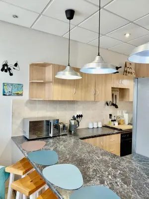 a kitchen with a counter with blue stools at The Tipsy Expat - Paarl - Self Catering Apartment in Paarl