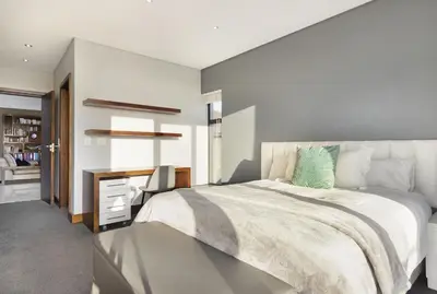 a bedroom with a large bed and a desk at Baronetcy Kings Villa in Plattekloof