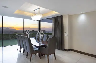 a dining room with a table and chairs at Baronetcy Kings Villa in Plattekloof