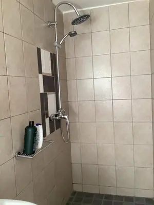 a shower with a shower head in a bathroom at Cozy Garden apartment with amazing view in Cape Town