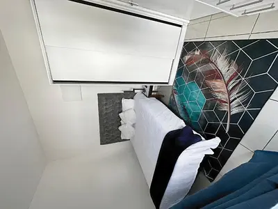 a small room with a bed and a mirror at Beatrice Guesthouse in Cape Town