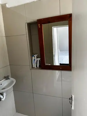 a bathroom with a mirror and a sink at Beatrice Guesthouse in Cape Town