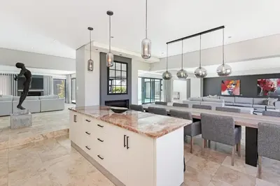 a kitchen and dining room with a table and chairs at Sunset Kite & Golf Villa in Cape Town