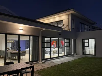 a house with a table and a dining room at Sunset Kite & Golf Villa in Cape Town