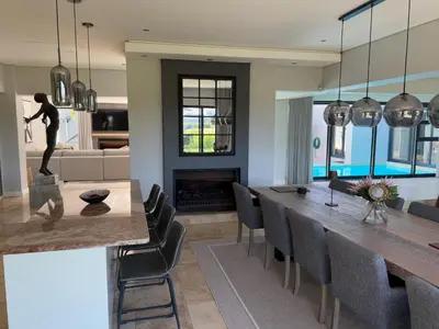 a kitchen and dining room with a table and chairs at Sunset Kite & Golf Villa in Cape Town