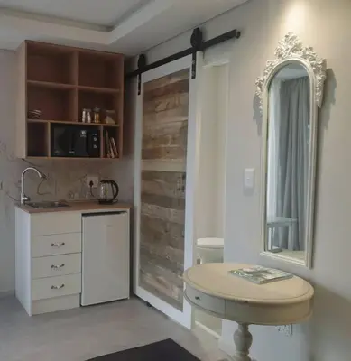 a kitchen with a sink and a mirror and a table at 4 Bed Selfcatering River Tree House overlooking the Onrus river in Hermanus