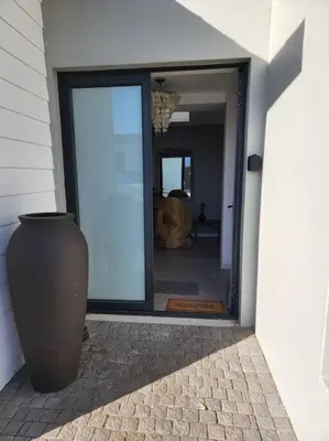 a large vase sitting in front of a doorway at 4 Bed Selfcatering River Tree House overlooking the Onrus river in Hermanus